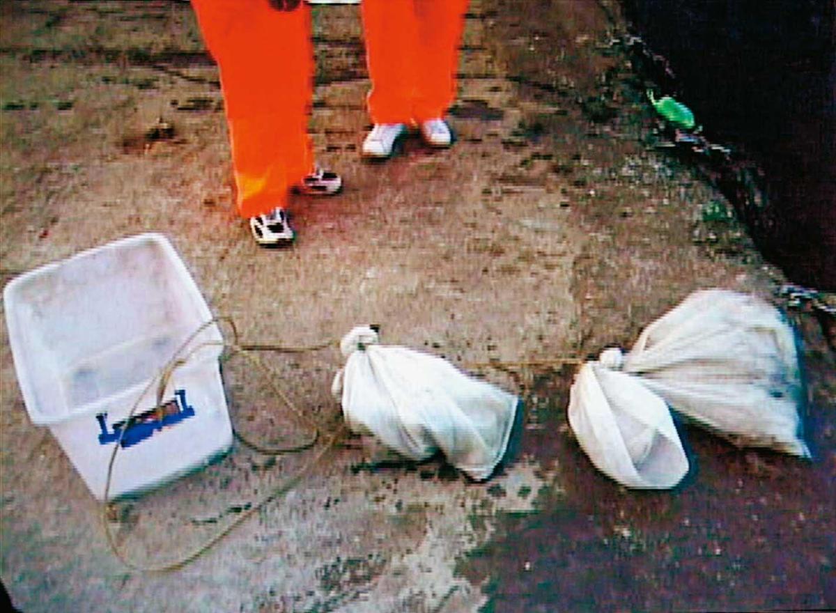 死者被打撈上岸時，身上纏著1個置物箱及2只裝著石頭的米袋。（圖／東森新聞提供）